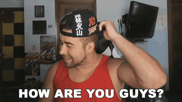 a man in a red tank top is wearing a hat that says " how are you guys " on it