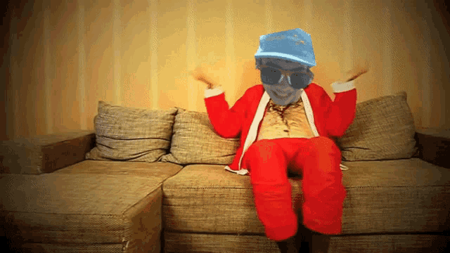 a man in a santa suit sits on a couch