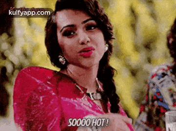 a woman in a red dress is making a funny face and saying `` soooo hot ! ''
