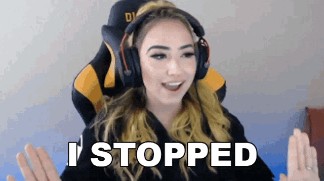 a woman wearing headphones says i stopped while sitting in a gaming chair