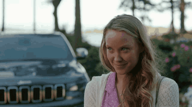 a woman stands in front of a jeep that says 00000 on the side