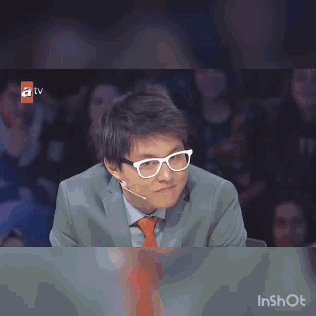 a group of people sitting around a table with a tv logo on the bottom