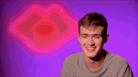 a man is smiling in front of a pink lips