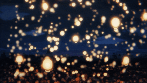 a bunch of lights are flying through the air at night
