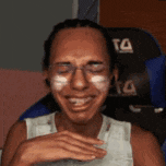 a man is sitting in a chair with his eyes closed and his face painted white .