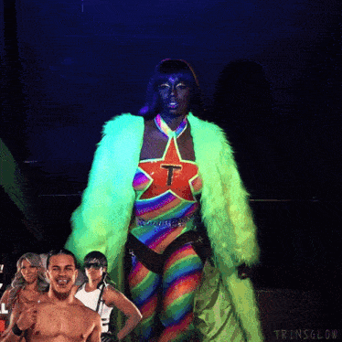 a group of people are standing around a woman in a rainbow outfit with a t on her chest