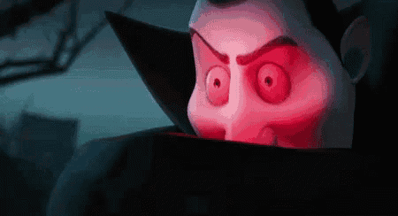 a cartoon vampire with red eyes and a black cape is looking at the camera .