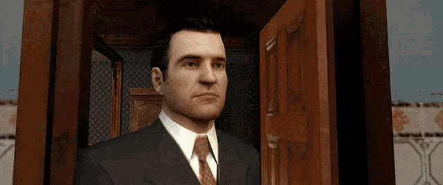 a man in a suit and tie stands in front of a door
