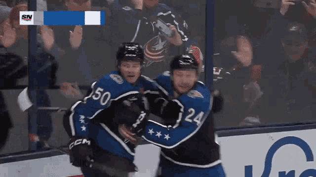 a hockey player wearing number 50 is hugging another player