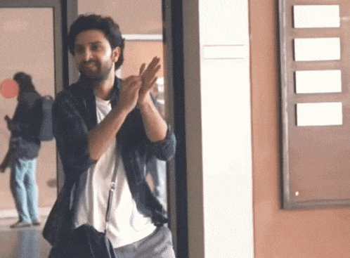 a man standing in a hallway with his hands in the air