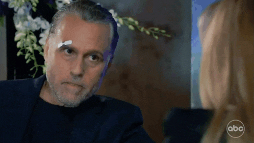 a man with a bandage on his forehead is talking to a woman on abc television