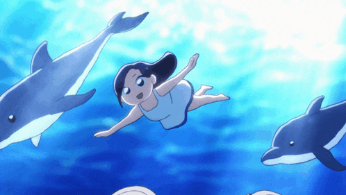 a girl is swimming in the ocean with two dolphins