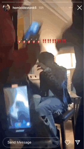a man is sitting on a chair talking on a cell phone while another man takes a picture of him .