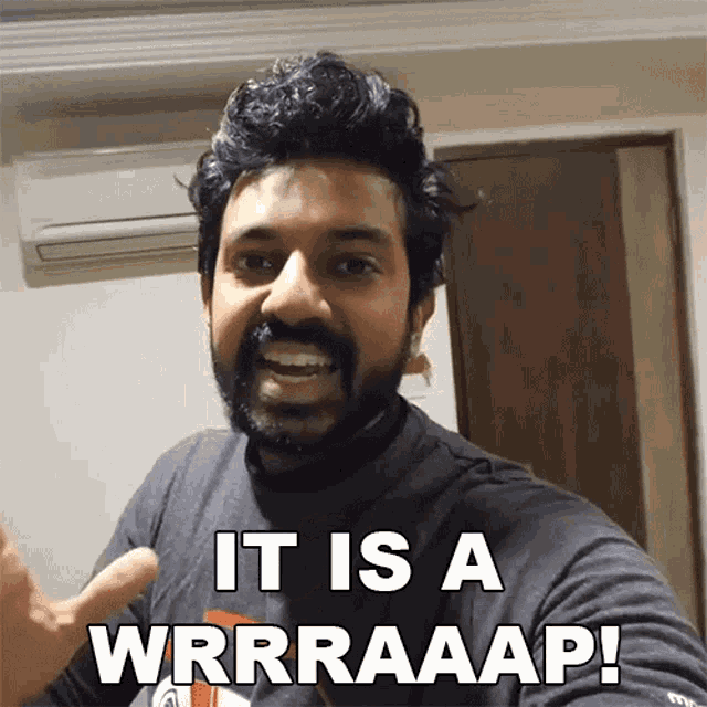 a man with a beard is giving a thumbs up and says " it is a wrrraaap "