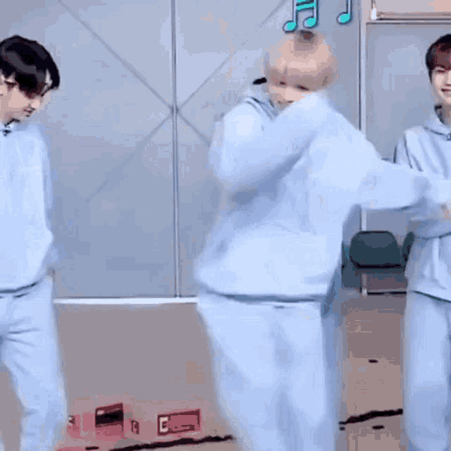 a group of people are standing next to each other in a room and dancing .