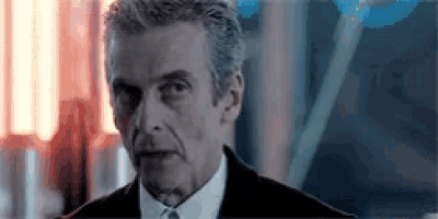 a man in a suit and tie is standing in front of a window .