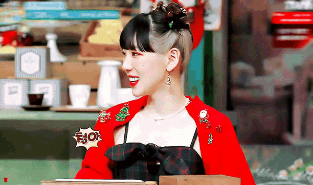 a woman with a shaved head is wearing a red jacket with a christmas tree on it