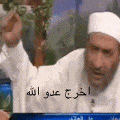 a man in a white hat with arabic writing on the bottom
