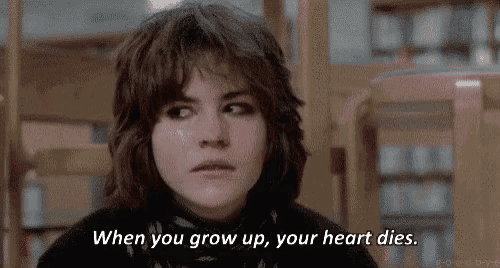 a girl is sitting in a library with the words `` when you grow up , your heart dies '' .