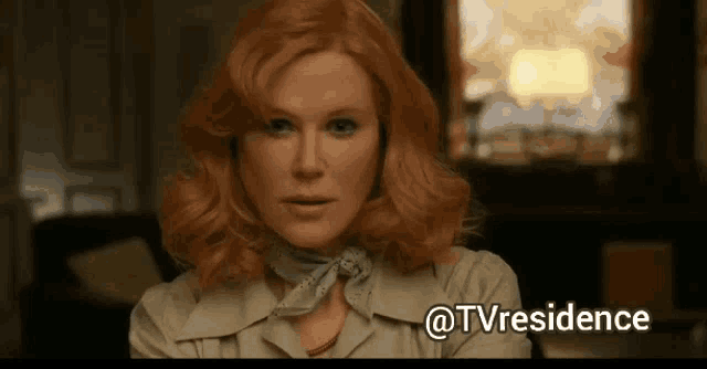 a woman with red hair and a scarf around her neck looks at the camera with the words @tvresidence below her