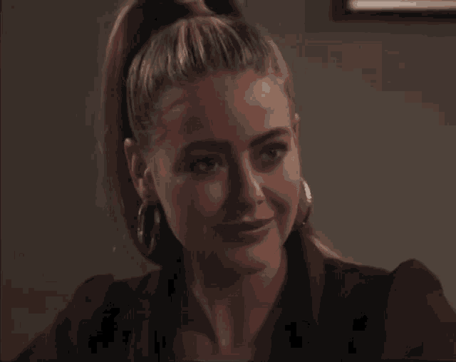 a close up of a woman 's face with a ponytail and hoop earrings