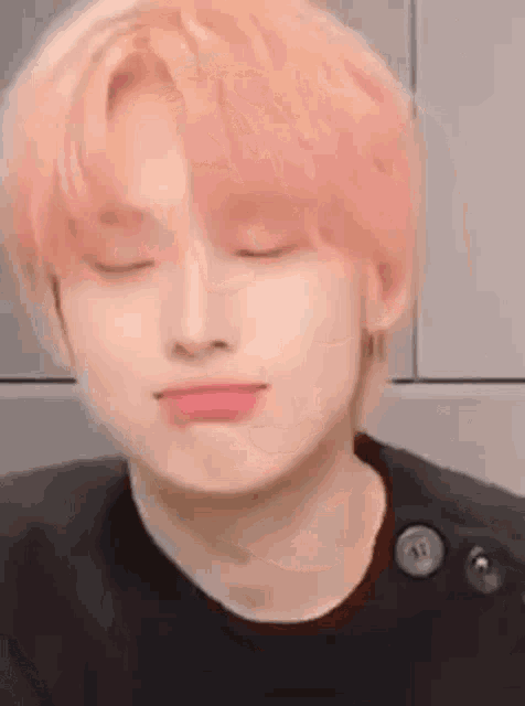 a close up of a person 's face with pink hair .