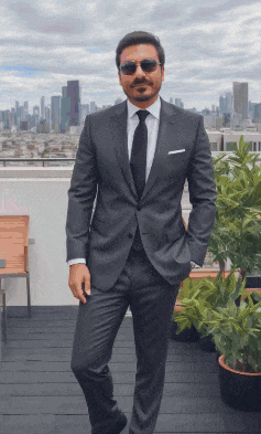 a man in a suit and tie is standing on a balcony with his hands in his pockets