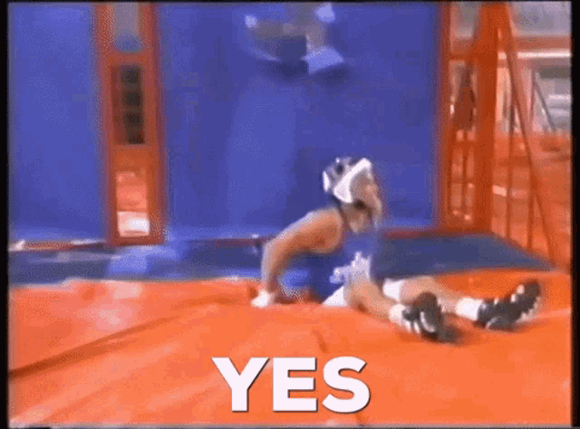 a man is laying on a trampoline with the word yes written above him
