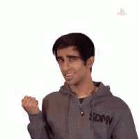 a man in a grey hoodie is flexing his muscles .