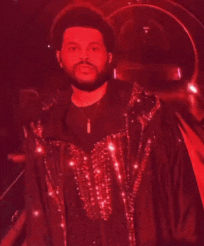 a man with a beard is wearing a red jacket with sequins on it .