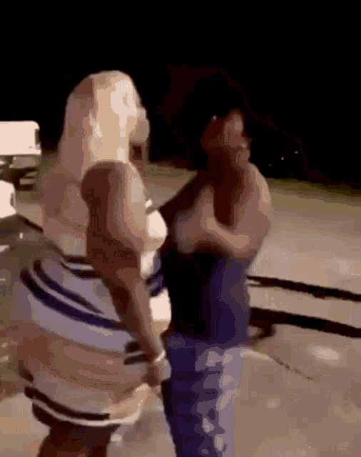 two women are standing next to each other on a sidewalk .