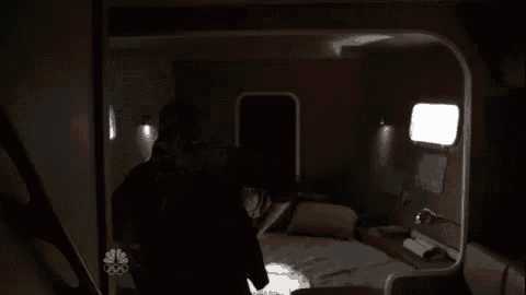 a man and a woman are kissing in the dark in a dark room .