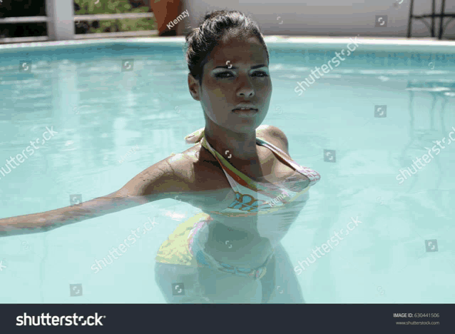a woman in a bikini is floating in a pool