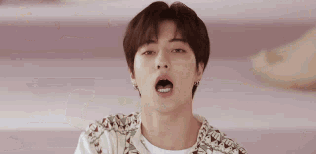 a young man making a funny face with his eyes closed and his arms outstretched