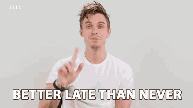 a man in a white shirt is pointing up and says better late than never .