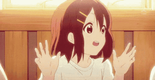 a girl in a white shirt is sitting in front of a wooden fence with her hands outstretched .