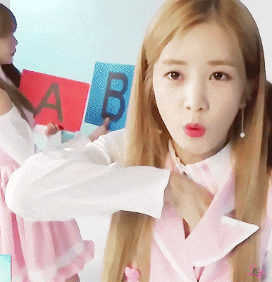 a girl in a pink dress holds a red and blue sign with the letter b on it
