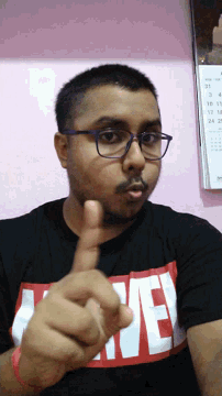 a man wearing glasses and a black shirt that says marvel