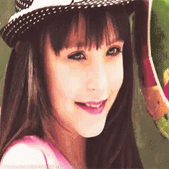 a young girl wearing a hat and a pink shirt