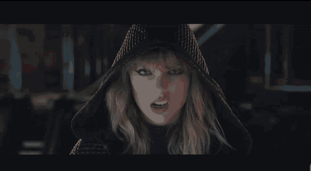 a close up of a woman wearing a black hooded jacket .