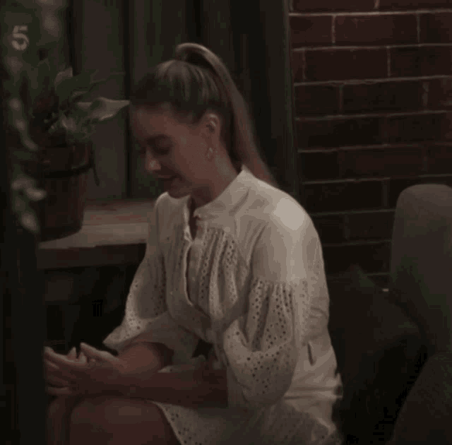 a woman in a white dress sits on a couch with the number 5 on the bottom