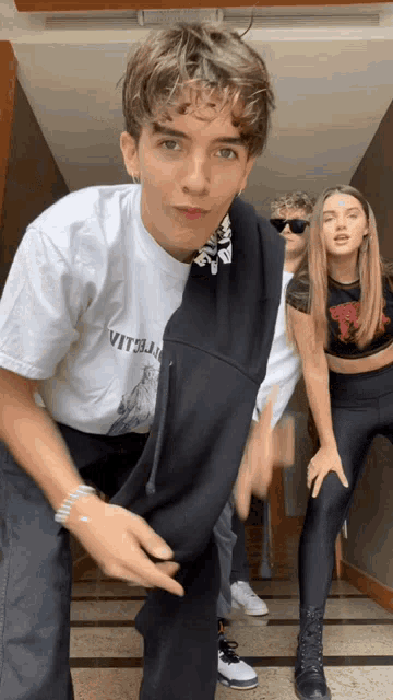 a man wearing a white shirt that says vitella is dancing
