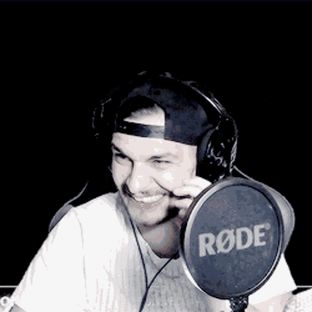 a man is wearing headphones and a rode microphone