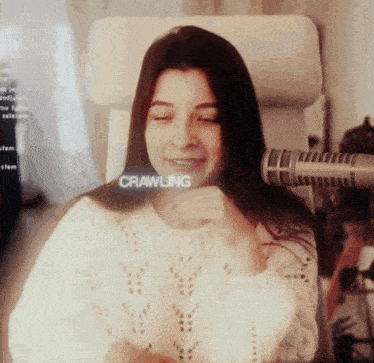 a woman is sitting in front of a microphone and the word crawling is on the screen