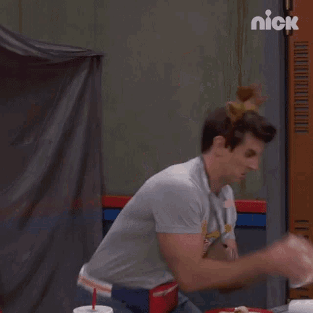 a man wearing a moose headband is eating a sandwich and throwing plates .