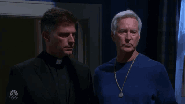 two men standing next to each other with the nbc logo visible