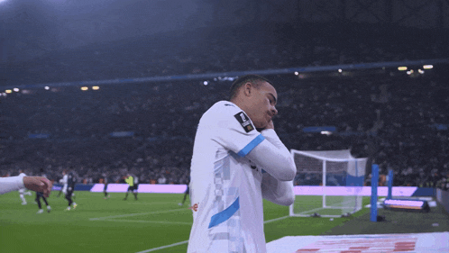 a soccer player wearing a white shirt with a blue stripe on the sleeve that says ' uefa ' on it