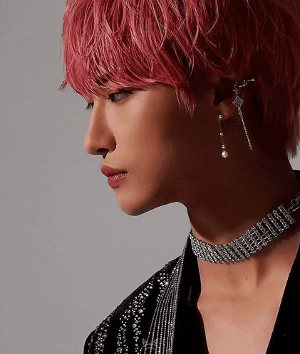 a close up of a person 's face with pink hair