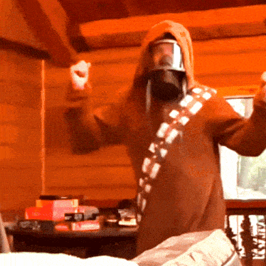 a man in a chewbacca costume holds a wii remote