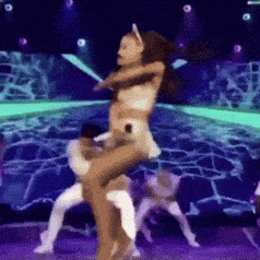 a woman is being lifted in the air by a man on a stage